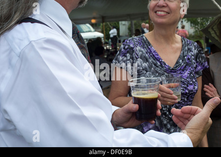 Frankenmuth, Michigan - People hold alcoholic drinks at a wedding reception. Stock Photo