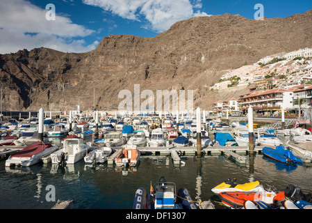 The marina in the harbour of the town of Los Gigantes, Tenerife, Canary Islands, with the giant cliffs of Los Gigantes behind Stock Photo