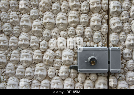 Many heads of plaster on a door, DOOR LOCK, decoration in Funchal, Madeira Stock Photo