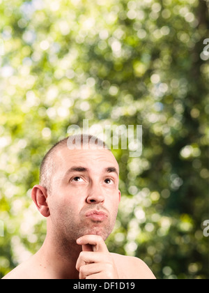 Caucasian man looking up and thinking on nature background Stock Photo