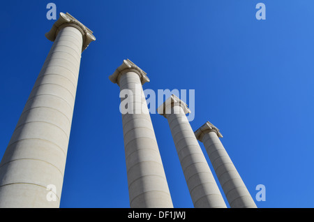 Four large columns reaching up to a blue sky. Stock Photo