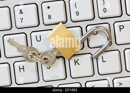 Unlocked padlock with a keys on the computer keyboard Stock Photo