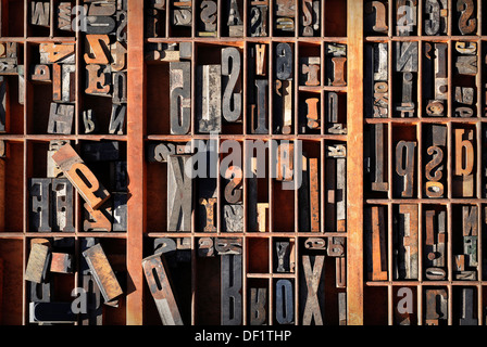A box of old vintage printing press letter blocks in a old wooden box Stock Photo