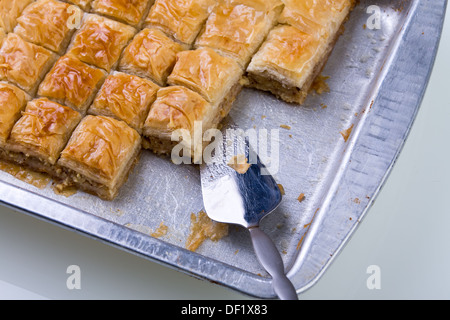 Home made baklava ready to serv from aluminum tray with brushed stailes-steel spatula Stock Photo