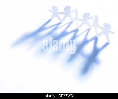 Line of paper doll people holding hands Stock Photo