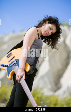 Nice looking young woman posing with yellow guitar Stock Photo