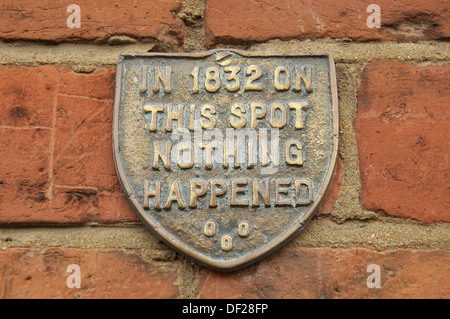 'In 1832 on this spot nothing happened'. The quirky words embossed on a plaque fixed to the brick wall of an old house in Bridport, Dorset, England. Stock Photo