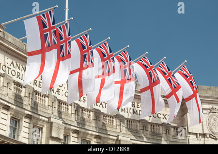 Royal Navy White Ensign flags fly in the breeze from Admiralty Arch. This famous London landmark was built over the Mall in 1912. England, UK. Stock Photo