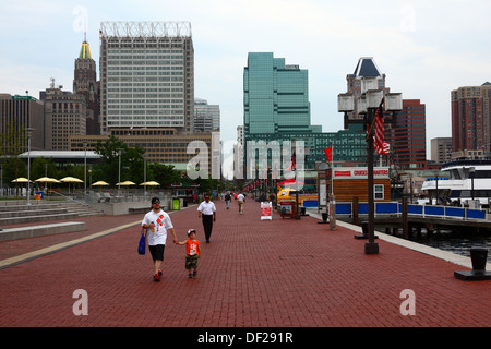 People walking along waterfront, Bank of America building in background left, Inner Harbor, Baltimore, Maryland, USA Stock Photo