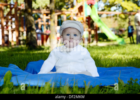 Boy with hat is sitting on blue plaid Stock Photo