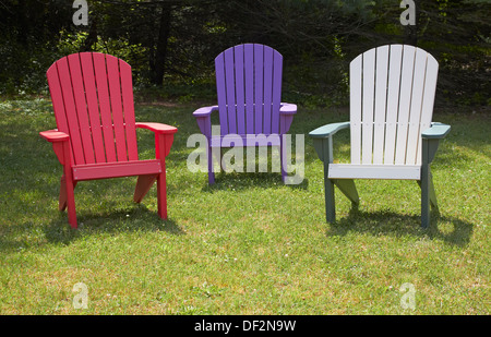 3 Adirondack chairs on lawn Stock Photo