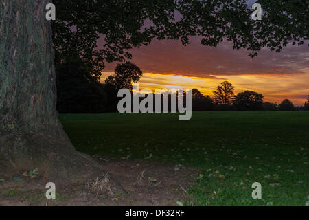 Northampton, UK. 27th Sep, 2013. As the Autumn sunrise begins to appear at Abington Park, Northampton, the sky over the town is filled with vivid colours. The UK has enjoyed unseasonably warm weather for September. Credit:  Keith J Smith./Alamy Live News