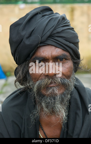 Bearded pilgrim dressed in black and wearing a black turban, Chauntra Bhater station, Kangra Valley Railway, Himachal Pradesh, India Stock Photo