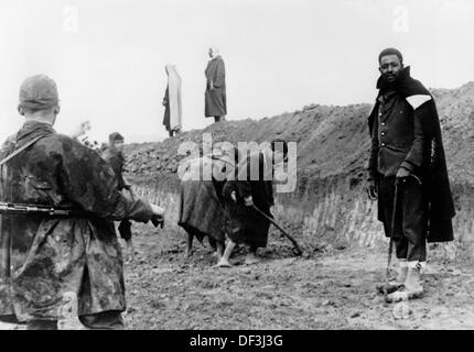 Soldiers of the German Wehrmacht supervise local workers digging trenches in Tunesia, 7 January 1943, place unknown. Nazi Propaganda! on the back of the image: 'Arabs build trenches under the supervision of German soldiers in Tunesia.' (Defects in quality due to condition of historical material.) Fotoarchiv für Zeitgeschichte Stock Photo