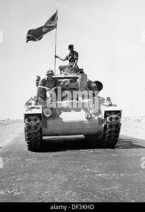 The image from the Nazi Propaganda! shows soldiers of the German Wehrmacht driving a captured English tank on a desert road in Africa, published on 30 January 1942. Place unknown. Fotoarchiv für Zeitgeschichte Stock Photo