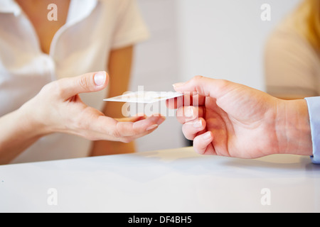 Hand of a patient giving smart card to doctors assistant Stock Photo