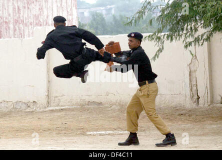 Elite Force Commandos of Police are showing their talent during 28th-29th passing out parade held at Razzaqabad Police Training Center of Karachi on Friday, September 27, 2013. Stock Photo