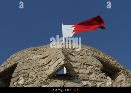 Turret of the Arad Fort in Muharraq, Kingdom of Bahrain, with the Bahrain flag flying Stock Photo