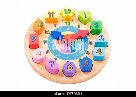 child's toy wooden clock with colourful number shapes on a white background Stock Photo