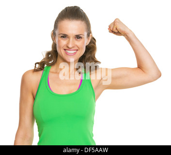 Smiling fitness woman show her biceps at gym Stock Photo by