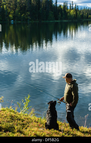 Fisherman and his labrador on the lake Stock Photo