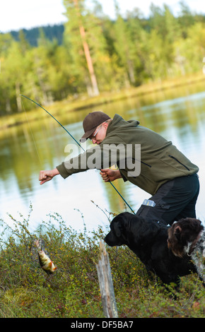 Fisherman get a perch with rod and reel, vertical image Stock Photo