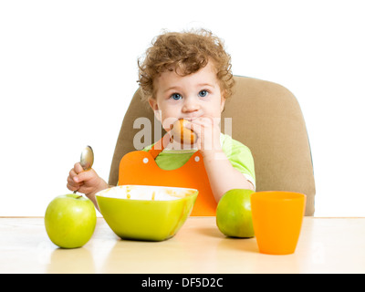 baby boy eating by himself Stock Photo