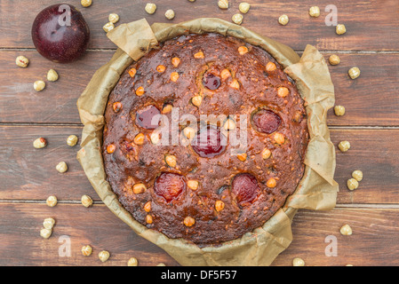 Plum, hazelnuts and chocolate home baked cake glazed with fruit jelly Stock Photo