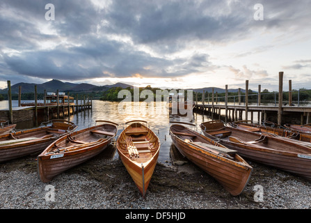 Rowing boats on the shore of Derwent Water in Keswick taken as the sun sets. Stock Photo