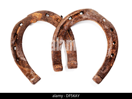 Old rusty and worn horseshoes isolated on white with natural shadows. Stock Photo