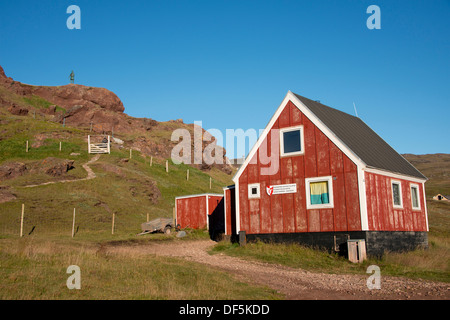 Greenland, Tunulliarfik (aka Erik's Fjord), Qassiarsuk, Brattahlid, Erik the Red's Eastern Settlement. Red cottage with Viking statue in the distance. Stock Photo