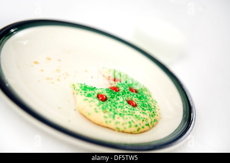 Christmas cookie missing a bite and milk left for Santa Claus. Shallow depth of field. Stock Photo