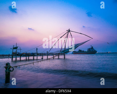 Kochi chinese fishnets and vessel on sunset in Kerala. Fort Kochin, South India Stock Photo