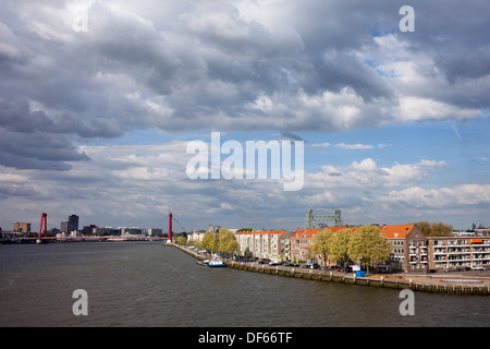 Houses along Nieuwe Maas (New Meuse) river in Rotterdam, Netherlands, Willemsbrug at the far end. Stock Photo