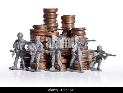 Plastic toy soldiers defending a pile of money Stock Photo