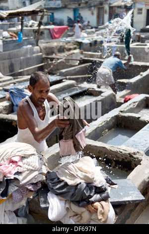 Indian man washing clothes at Mahalaxmi Dhobi Ghat or laundromat Mumbai India Stock Photo