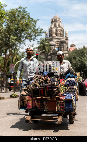 Dabbawala or dabbawalla or dabbawallah collecting freshly cooked food in lunch boxes Mumbai India Stock Photo