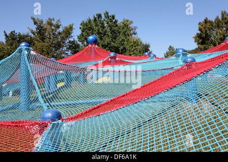 Blue and red spider net construction on kids playground Stock Photo