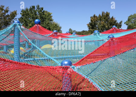 Blue and red spider net construction on kids playground Stock Photo