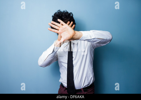 Young man is protecting his face form blinding lights Stock Photo