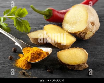 Fresh ginger root, red chili & ground turmeric. Indian spices composed arrangement Stock Photo