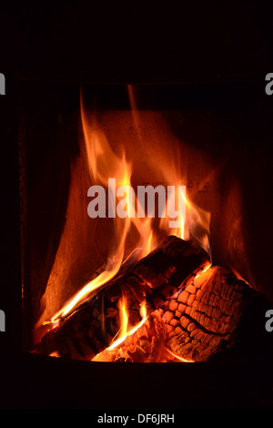 Log fire with glowing embers in open hearth Stock Photo