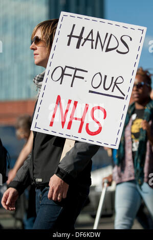 Manchester, UK. 29th Sept 2013. A protestor holding a sign reading 'Hands off our NHS' during a North West TUC organised march and rally intending to defend National Health Service (NHS) jobs and services from cuts and privatisation. The march coincides with the Conservative Party Conference 2013 being held in the city. Credit:  Russell Hart/Alamy Live News. Stock Photo