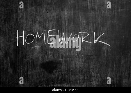 The word homework written in chalk on a blackboard Stock Photo