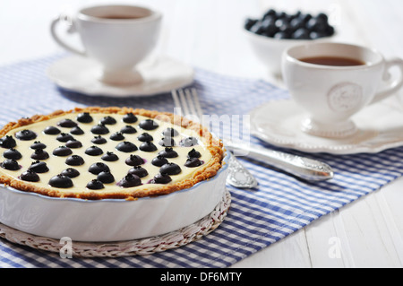 Blueberry tart with cup of tea on checkered background Stock Photo