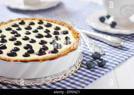 Blueberry tart with cup of tea on checkered background Stock Photo