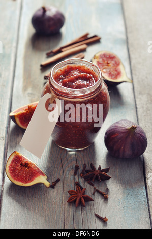 Fig jam in a glass jar with fresh figs on wooden background Stock Photo