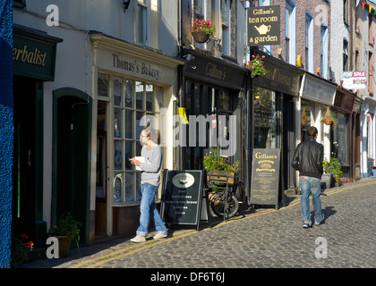 Young woman walking into bakery, Market Street, Ulverston, Cumbria, England UK Stock Photo