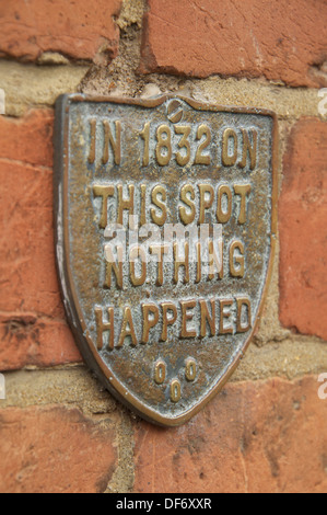 'In 1832 on this spot nothing happened'. The quirky words embossed on a plaque fixed to the brick wall of an old house in Bridport, Dorset, England. Stock Photo