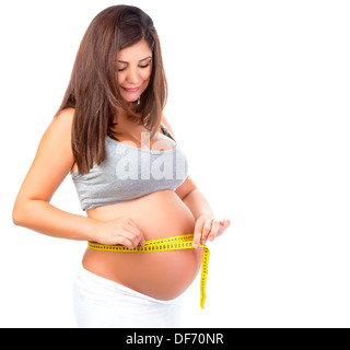 Portrait of happy pregnant woman measuring belly, isolated on white background, size control, healthy pregnancy Stock Photo